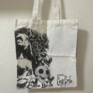  tygväska  - Säljer en cool vit tygväska med tryck från Tim Burton's Corpse Bride. 🩷 den ser likadan ut på båda sidorna 