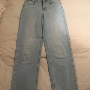 Ljusblå jeans från Gina Tricot - Snygga ljusblå jeans från Gina Tricot med klassisk femficksdesign. De har en rak passform och är perfekta för en avslappnad stil. Märket 'perfect jeans' ger en skön och bekväm känsla. Perfekta för vardagsbruk!