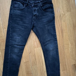 Svarta jeans från Valentino - Snygga svarta jeans från Valentino med en diskret tvättad look. De har en klassisk femficksdesign och en tydlig logga på bakfickan. Perfekta för en stilren och modern look.