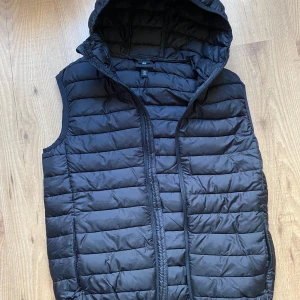 Vest - Dunväst från HM. Skick 9/10, Luva finns. Inte alls mycket använd. Skön väst att ha till våren.