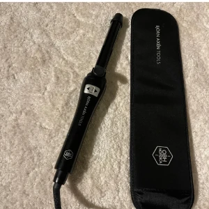 Svart locktång från Björn Axén Tools - Nypris: 1379 kr.  Genius Curler, den smarta, automatiska locktången från Björn Axén Tools som lockar ditt hår åt dig. Det enda du behöver göra är att välja vilket håll locken ska gå - mot ansiktet eller bort från ansiktet. Resten räknar Genius Curler ut åt dig. Genius Curler känner av din hårlängd och anpassar locken efter ditt hår. Locktången rullar in ditt hår och piper när locken är färdig. Om du ändå vill locka själv kan du dessutom stänga av det automatiska läget. Kommer med förvaringsväska