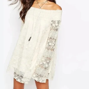 Vit spetsklänning - Charmig vit offshoulder klänning i spets med långa ärmar. Perfekt för en romantisk look med sina vackra spetsdetaljer och luftiga passform. Klänningen har en bohemisk känsla och är idealisk för varma dagar. Storlek S (M).  Helt ny.