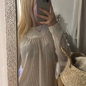Vit långärmad topp - Säljer en söt vit långärmad topp med spetsdetaljer runt halsen. Toppen har en ribbad struktur och är perfekt för en avslappnad stil. Passar bra till både jeans och kjol. 🌼Passar som storlek xs