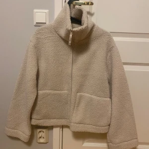 Ny ljusbeige pilejacka i storlek S från H&M - Ny med tags. Färg: ljusbeige / naturvit Storlek: S Passformen är i en normal avslappnad form. Ta en storlek större än din vanliga storlek om du vill ha plats för en tjocktröja under annars kan det blir lite tajt.