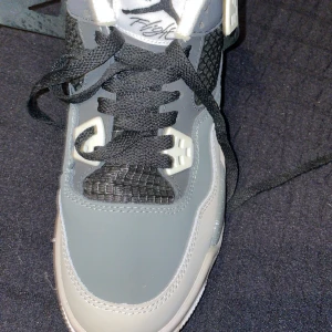 Gråa jordans - Säljer ett par gråa Nike sneakers i mycket bra skick. De har en snygg design med svarta och vita detaljer samt snörning. Perfekta för både vardag och träning. Sulan har en cool stänkmönster och den klassiska Jumpman-loggan syns tydligt. Storlek 39.