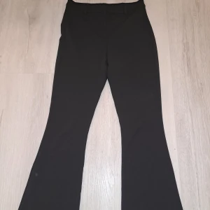 Svarta bootcut kostymbyxor  - Säljer pga att dom är stora för mig och därför inte används längre💞 ett par svarta bootcut byxor i mycket bra skick. De är högmidjade och har en snygg passform som sitter tight upptill och blir vidare nedtill. Perfekta för både vardag och fest! Mater