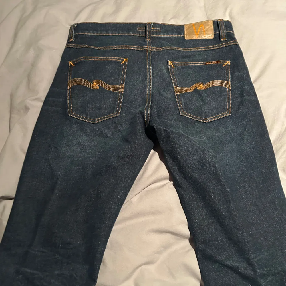 Säljer ett par snygga mörkblå jeans från Nudie Jeans i storlek 32W- L30. De är i väldigt fint skick och lappar och sånt finns kvar,vid frågor eller intresse är det bara skriva!!                                               Kan hämnats i Stocholm(Haninge) eller fraktas men köparen står för frakten!!. Jeans & Byxor.