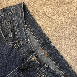 Mörkblå jeans  - Säljer ett par snygga mörkblå jeans från Mingel i bra skick. De är midwaist och blandning mellan flare och straigh. Perfekt till vintern och är superbekväma.