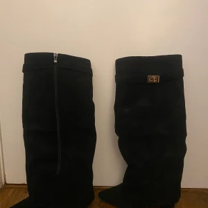 Svarta stövlar med spänne - Snygga svarta stövlar i mocka med dekorativt spänne upptill. Använda 1 gång, väldigt bra skick. Lite stor i storleken 