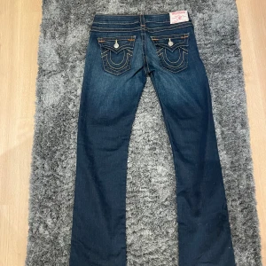 Mörkblå true religon  - Säljer ett par super snygga true religon jeans. Nästan aldrig använda, säljer på grund av att de var förstora. Dom har ett super litet hål på sidan men inget man märker skriv gärna för fler bilder💕