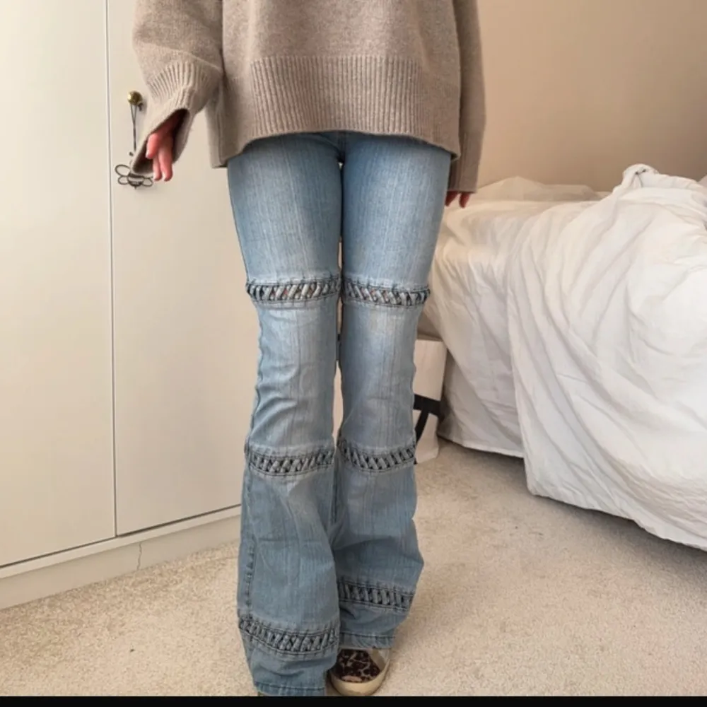 Säljer ett par snygga blå bootcut jeans med unika detaljer. De har en cool design med ribbade partier runt benen som ger en extra touch. Perfekta för både vardag och fest! Passar bra till en oversized tröja och sneakers för en avslappnad look.. Jeans & Byxor.