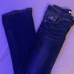 Mörkblåa jeans - Säljer ett par mörkblåa low waist bootcut jeans i bra skick. Använd ganska mycket men i bra skick, inga defekter. Köpta på Gina men säljs inte längre. Nypris: 400kr.