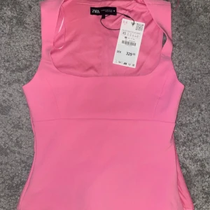 Rosa ärmlös topp från Zara - Säljer en snygg rosa ärmlös topp från Zara i nytt skick. Toppen  är gjord i ett mjukt material som känns skönt mot huden. Nypris 329 kr, aldrig använd! Storlek xs men kan upplevas lite stor i storlek