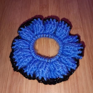 Blå och svart stickad scrunchie - Snygg och unik virkad scrunchie i blått med svarta detaljer. Perfekt för att ge din frisyr en färgglad touch. Den är elastisk och passar de flesta hårtyper. Perfekt accessoar för både vardag och fest! Skulle du vilja ha en i en specifik färg är det bara att skriva. Alla accessoarer är gjorde av mig.
