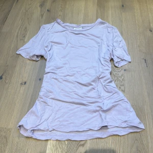 Ljuslila topp från Vero Moda - Säljer en ljuslila topp från Vero Moda i storlek XS. Toppen är kortärmad och har en enkel design som passar perfekt till vardags. Materialet känns mjukt och bekvämt, perfekt för vår och sommar.