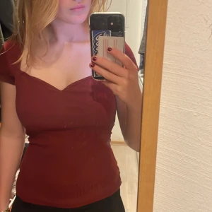 Vinröd topp från Anna field  - Säljer en snygg vinröd topp med korta ärmar och en v-ringad design.