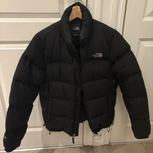 Svart dunjacka från The North Face - Säljer en svart dunjacka från The North Face i mycket bra skick. Den har långa ärmar och en dragkedja framtill. Nypris 3000kr