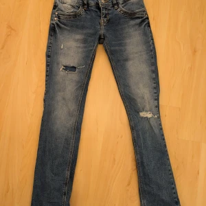 Blå jeans med slitningar - Säljer ett par coola blå LBT jeans med slitningar! Dessa är i bra skick och har används av ett barn. 