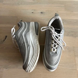 Grå platform sneakers med vit sula - Säljer ett par grå sneakers  med vit sula och snörning. Köpta second hand så lite tecken på användning. De har en chunky design och är riktigt bekväma för vardagsbruk. Perfekta för både vår och höst!