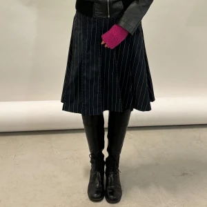 Svart och vit randig kjol - Snygg svart kjol med vita ränder. Kjolen har en klassisk A-linjeform och är perfekt för både vardag och fest. Den är knälång och har en stilren design som passar till många olika outfits. Perfekt för höst och vår!