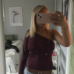Vinröd oneshoulder-topp från MQ - Säljer en snygg vinröd oneshoulder-topp från MQ. Passar till fest och vardags. Aldrig andvänd så är i perfekt skick. Färgen kan missuppfattas lite på dom tre första bilderna men man ser tydligare på sista bilden💝köpt ny runt 500kr
