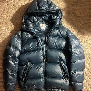 Blå pufferjacka från Zara - Säljer en snygg blå pufferjacka från Zara i mycket bra skick, med dun i. Köptes för ett år sen men var för liten därför är den mycket lätt använd. Passar både tjejer och killar Storlek S