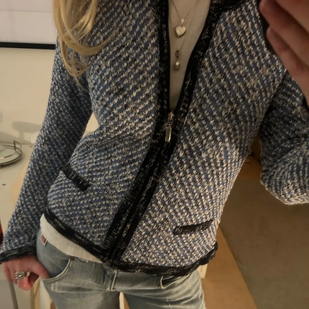 Säljer en snygg blå och vit mönstrad cardigan med dragkedja framtill. Den har en normal passform och är perfekt för både vår och höst. Perfekt för att piffa upp vardagsoutfiten! Använd sparsamt 💗. Tröjor & Koftor.