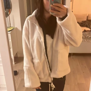 Vit teddyjacka - Mysig vit teddyjacka med dragkedja framtill helt ny. Perfekt för kyliga dagar med sin fluffiga och varma känsla. Jackan har långa ärmar och två fickor. Passar bra till både vardag och avslappnade tillfällen.💕💕💕
