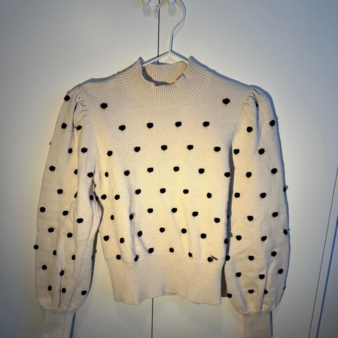 Vit stickad tröja med svarta prickar