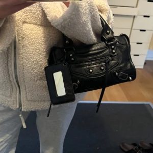 Väska - Fin väska i bra skick, enda defekt är att remmarna på dragkedjan gått bort som man ser på bild tre. Band medföljer. 