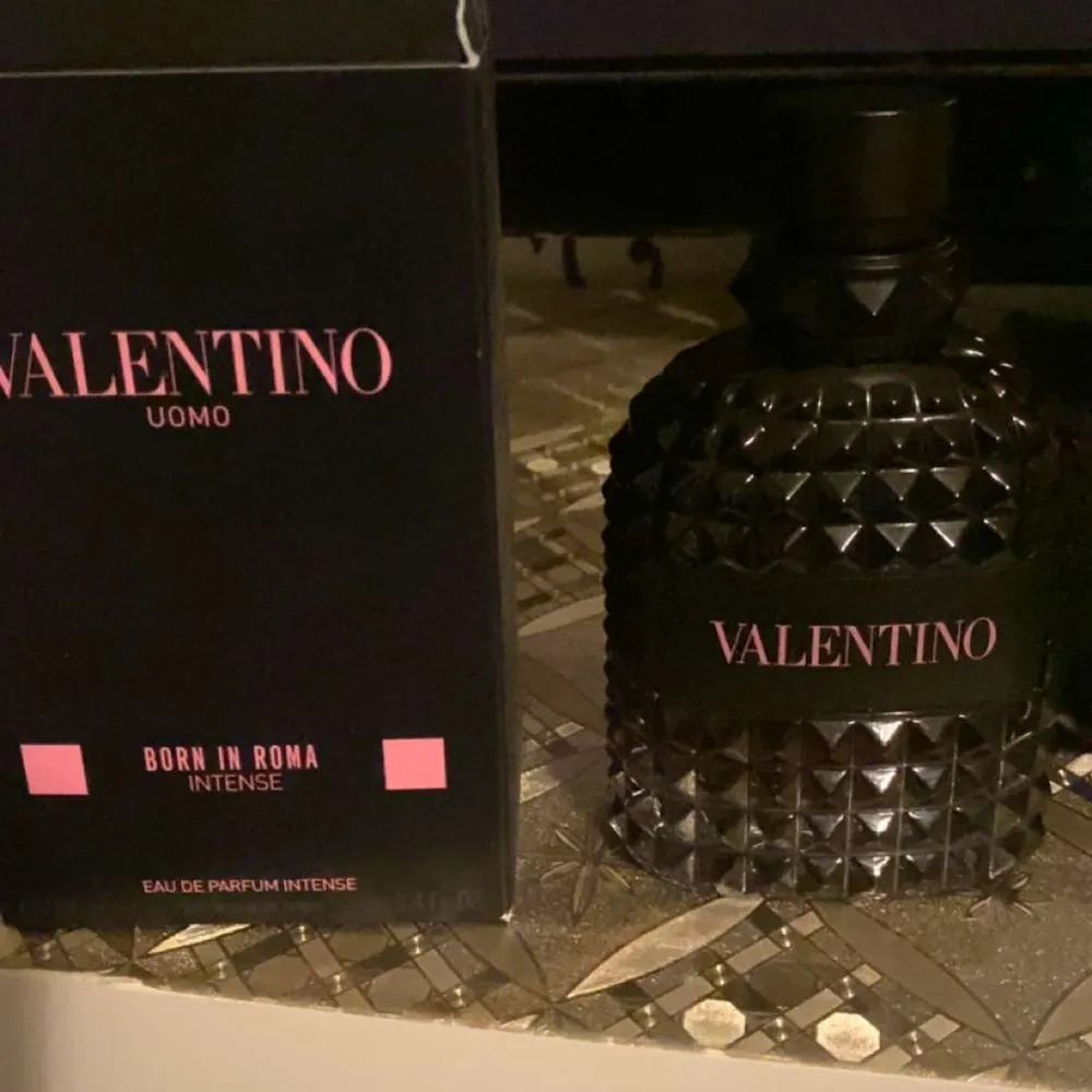 Säljer en lyxig parfym från Valentino, Uomo Born in Roma Intense. Flaskan är svart med ett coolt nitat mönster och rymmer 100 ml. Perfekt för den som vill ha en intensiv och elegant doft. Kommer med originalförpackning. Det är 55ml kvar på flaskan . Parfym.