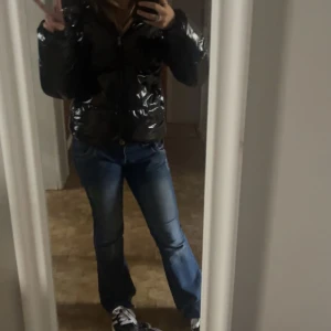 Svart glansig pufferjacka - Säljer en svart glansig pufferjacka i mycket bra skick. Jackan har en dragkedja framtill och är perfekt för höst och vinter. Den är långärmad och har en normal passform. Perfekt för att hålla sig varm och stilren till kalla vinterdagar. Är i storlek M men sitter som S/xs. Och är från Nelly! Har fler bilder kom privat!❤️