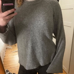 Grå stickad tröja - Mysig grå stickad tröja med långa ärmar och ribbade detaljer vid ärmslut och nederkant. Perfekt för kyliga dagar och passar till både jeans och kjol. Skön och stilren design som funkar till vardags. 💕