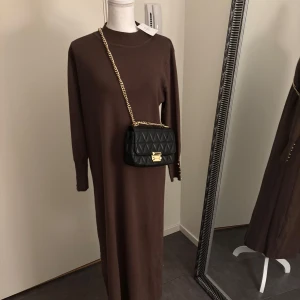 Golden Button Sweater Dress | Brown - Hej! Detta är mitt företag, och du kan köpa produkterna här på plick eller via vår hemsida: Nooralanna.com. Det pris som anges här är fast, och jag kommer inte att svara på meddelanden om budgivning. Tack för förståelsen!  Retur gäller endast via beställning på hemsidan. Läs retur policy vad som gäller.   Tillgängliga storlekar och lagerstatus: 	•	S/M: 3 st i lager 	•	M/L: 3 st i lager 	•	L/XL: 3 st i lager  Vänligen kontakta mig endast vid seriösa frågor eller köp. Tack!
