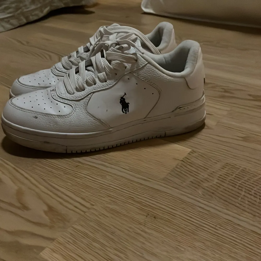 Säljer ett par vita sneakers från Polo i bra skick. De har en klassisk design med snörning och en diskret logga på sidan. Perfekta för vardagsbruk och passar till det mesta. Sulan är lite smutsig men kan lätt rengöras. Sköna och stilrena!. Skor.