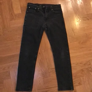 Svarta Levi's 502 jeans - Säljer ett par svarta Levi's 502 jeans i bra skick. De har en klassisk straight passform och är perfekta för både vardag och fest. Jeansen är tillverkade i slitstarkt denim och har de ikoniska bakfickorna med Levi's logga. Perfekta för höst och vinter! Notera dock att det finns ett litet hål på baksida ben men som knappt märks. Priset är inte hugget i sten😁