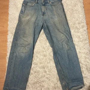 Blå jeans - Säljer ett par klassiska blå jeans i bra skick. De har en straight passform och är perfekta för vardagsbruk. Jeansen har en traditionell femficksdesign och är tillverkade i slitstarkt denim. Perfekta för både höst och vår!