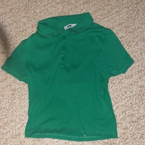Grön pikétröja från FB Sister - Säljer en snygg grön pikétröja från FB Sister i storlek S. Tröjan har en klassisk krage och knappar framtill. Perfekt för en casual look eller en dag på golfbanan. Passar bra till både jeans och kjol. Hör av dig vid intresse! 💚