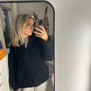 Svart teddyjacka från Carin Wester  - Mysig svart teddyjacka från Carin Wester i storlek xs. Perfekt för kyliga höst- och vinterdagar. Jackan har en dragkedja framtill och långa ärmar. Den är supermjuk och varm, idealisk för att hålla stilen när det är kallt ute. 🖤