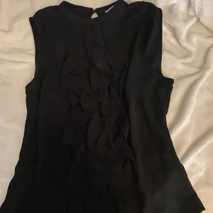 Svart blus  - Snygg svart blus från H&M med volangdetaljer framtill💕