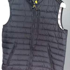 Svart dunväst med dragkedja - Säljer en svart dunväst från Parajumpers Stl L. Väldigt fint skick förutom dem två skador som finns. 