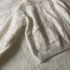 Vit stickad tröja - Mysig vit stickad tröja med ett fint mönster och ribbade kanter. 