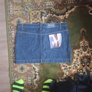 Jeanskjol från Svea - Snygg jeanskjol från Svea i klassisk blå denim. Kjolen har en kort längd med en knapp och dragkedja framtill samt fickor både fram och bak. Perfekt för en avslappnad stil.