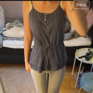 Söt sommar topp - Säljer en snygg blå ärmlös topp med knappar framtill och knytband i midjan samt knappar😍😽