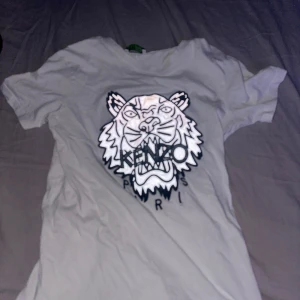 Vit t-shirt från Kenzo med tigertryck - Säljer en vit t-shirt från Kenzo med ett stort tigertryck och texten 'Kenzo Paris' på framsidan. 