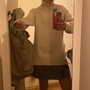 Beige polotröja - Säljer en stilren beige polotröja med långa ärmar. Perfekt för kyligare dagar och enkel att matcha med olika outfits. Tröjan har en klassisk design med ribbade muddar vid ärmslut och nederkant.