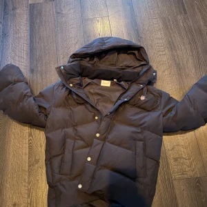 Jacka från märket GANT  - En helt oanvänd puffer jacka från märket gant.jackan har både knappar och dragkedja. Jackan har ett ny pris på ca 2000kr men hos oss kan du hitta den föra bara 1500k