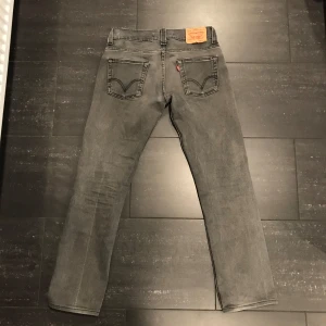 Grå Levis 511 jeans - Snygga grå Levis 511 slim jeans med en klassisk femficksdesign. De har en dragkedja och knapp framtill. Perfekta för en stilren look. Slim modell men sitter mer som en normal/straight passform. Riktigt shyssta! Inga defekter alls. Skick 10/10. Storlek 32/34
