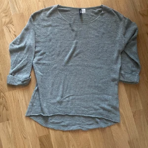 Militärgrön  tröja från H&M Divided stl S - Säljer en stilren militärgrön tröja från H&M Divided. Tröjan har trekvartsärmar och en rund halsringning. Perfekt för en avslappnad look. Passar bra till jeans eller kjol.