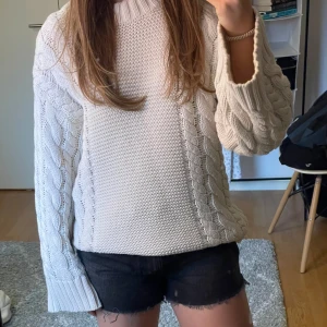 Vit stickad tröja med flätmönster - Säljer en mysig vit stickad tröja med flätmönster. Tröjan har långa ärmar och en ribbad krage. Perfekt för kyligare dagar. Passar bra till jeans eller kjol. 🧶✨